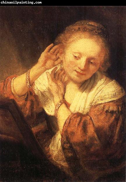 REMBRANDT Harmenszoon van Rijn Young Woman Trying on Earrings