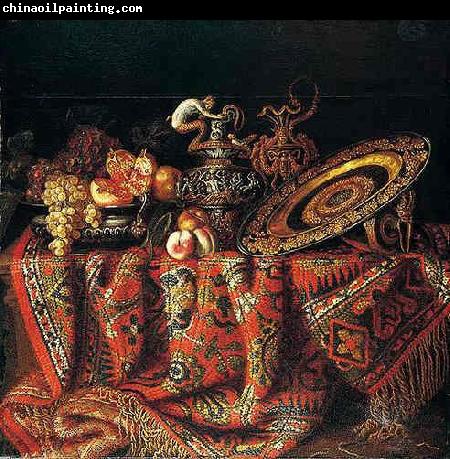 Jacques Hupin A still life of peaches, grapes and pomegranates in a pewter bowl, an ornate ormolu plate and ewers, all resting on a table draped with a carpet